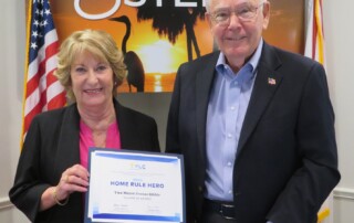 Mayor Jon McLain presenting Vice Mayor Joanne Ribble with the Florida League of Cities “Home Rule Hero Award.”